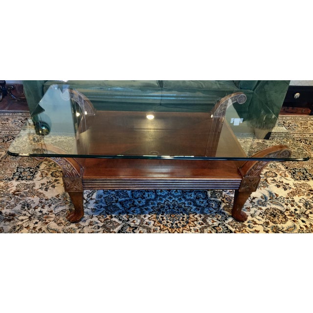 Carved Cherry Wood With Glass Top Coffee Table | Chairish This is a coffee table that features a round top made of solid glass.